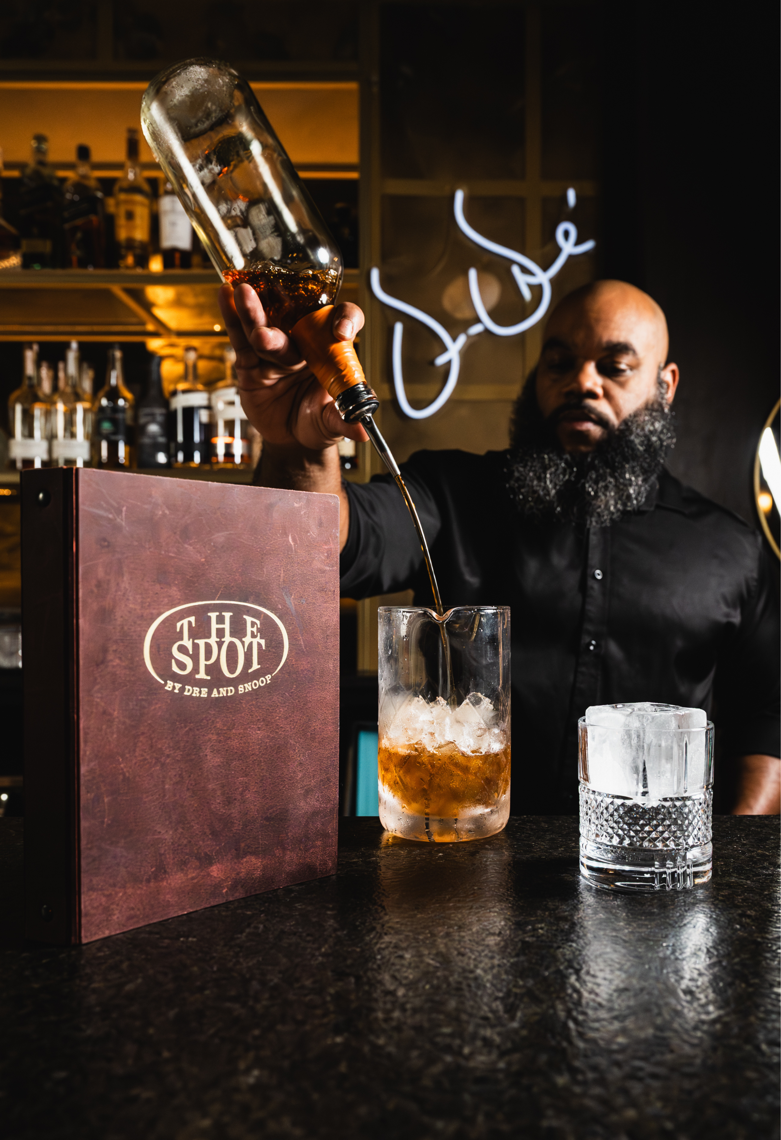 Bartender pouring a drink at The Spot By Dre and Snoop.