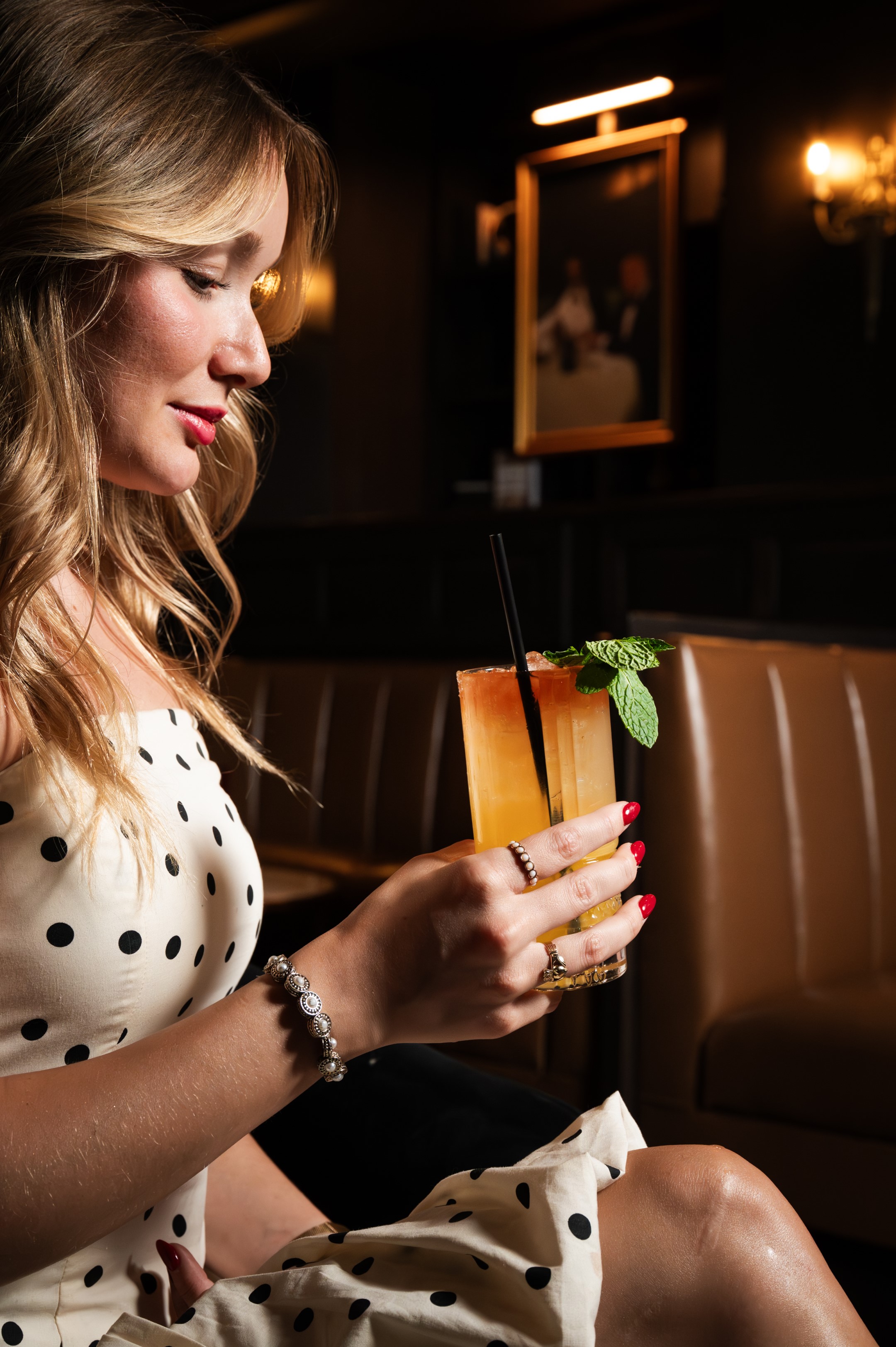 Woman holding a colorful cocktail.