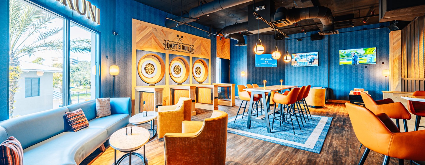 Games area with three dart boards and seating at Sports & Social at Live! at the Pointe Orlando.