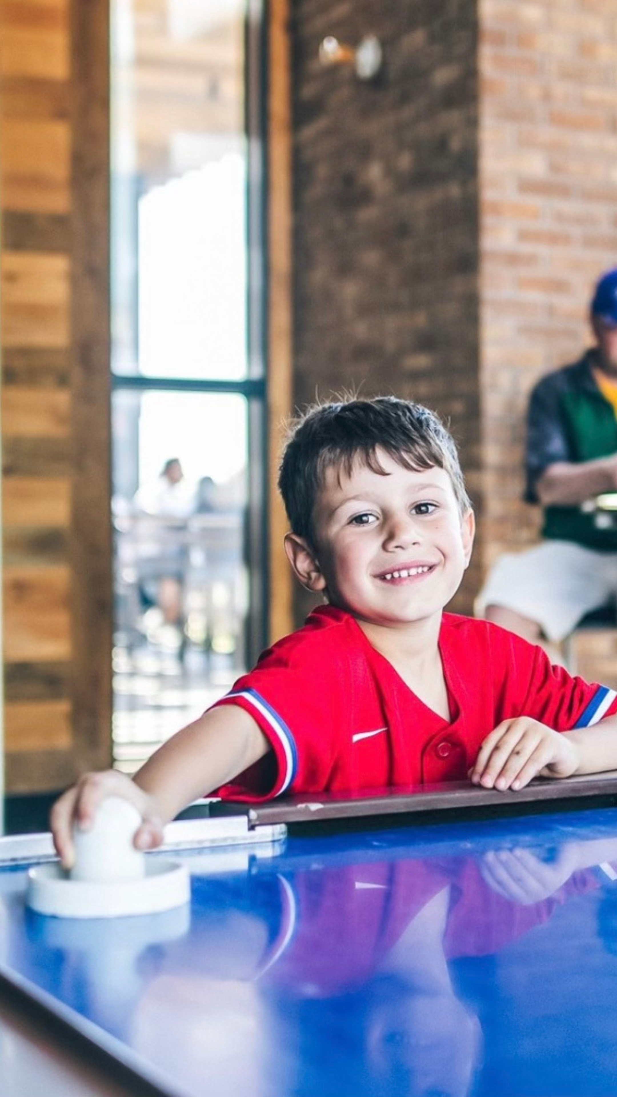 Young boy playing air hockey at Sports & Social at Texas Live!