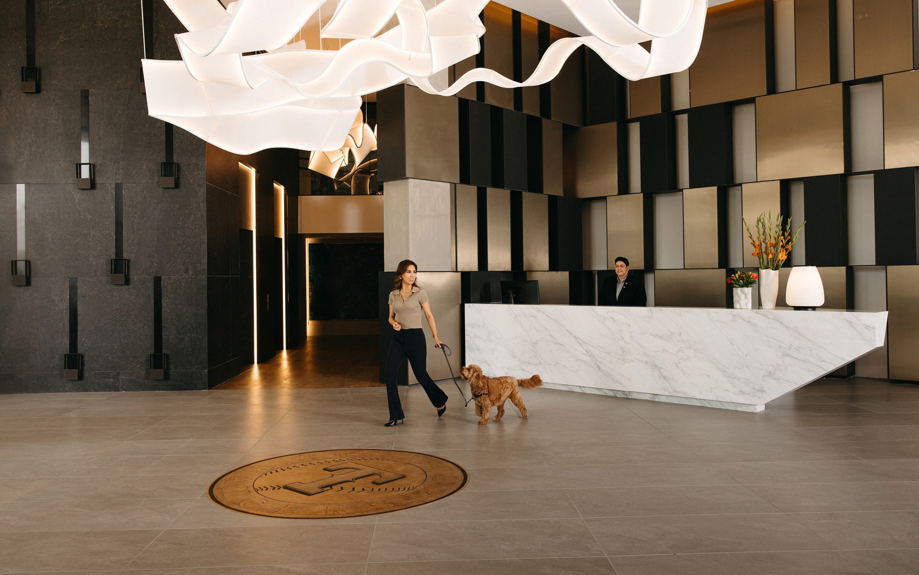 Woman walking a dog at the One Rangers Way lobby