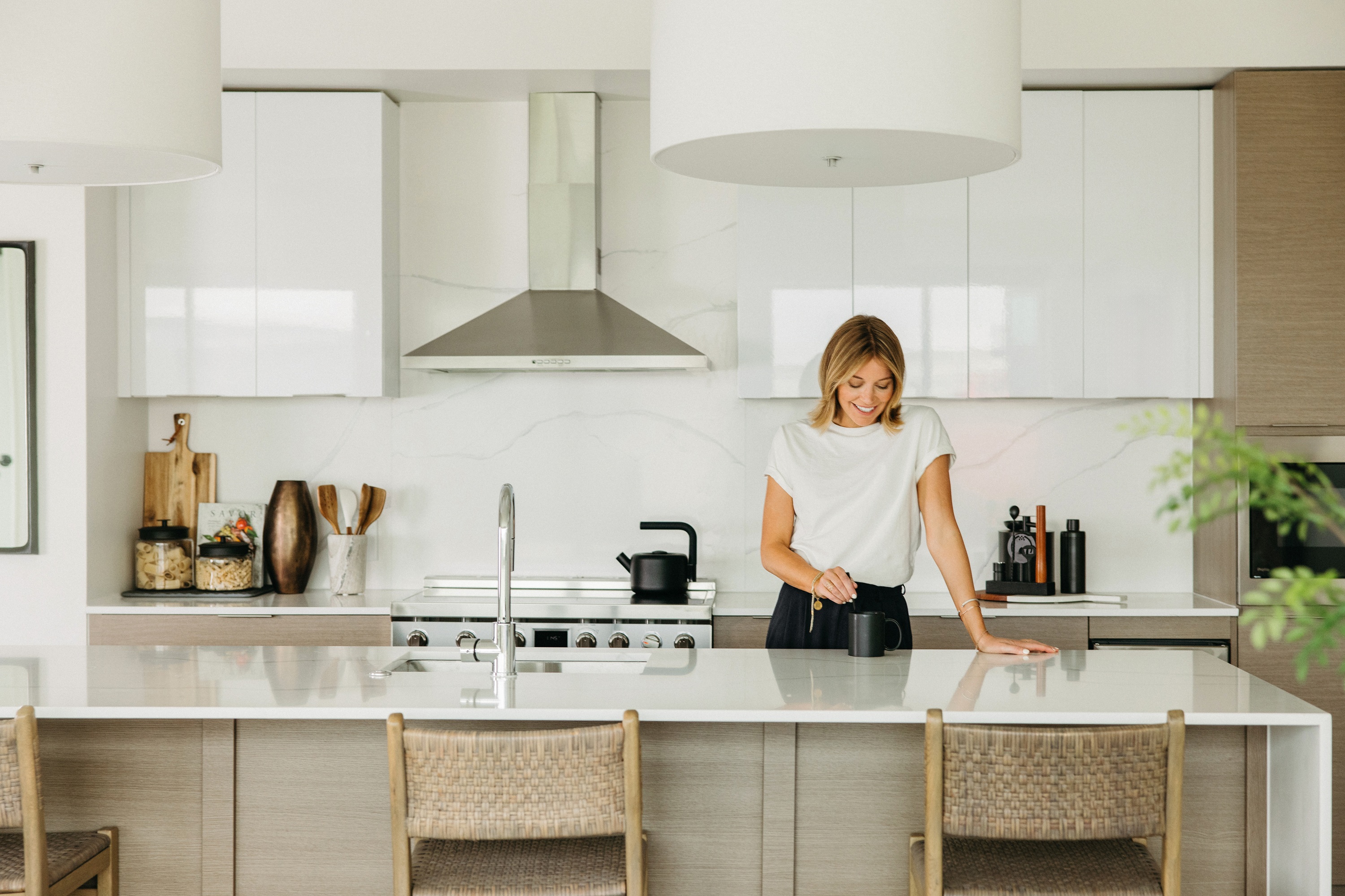 Woman enjoying a cup of coffee at One Rangers way penthouse kitchen 