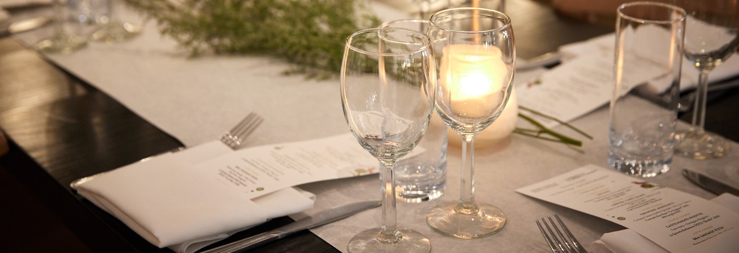 Katie's Wine Dinner Table setting with utensils, linens, menus, glassware, and candles at Katie's Pizza & Pasta Osteria.