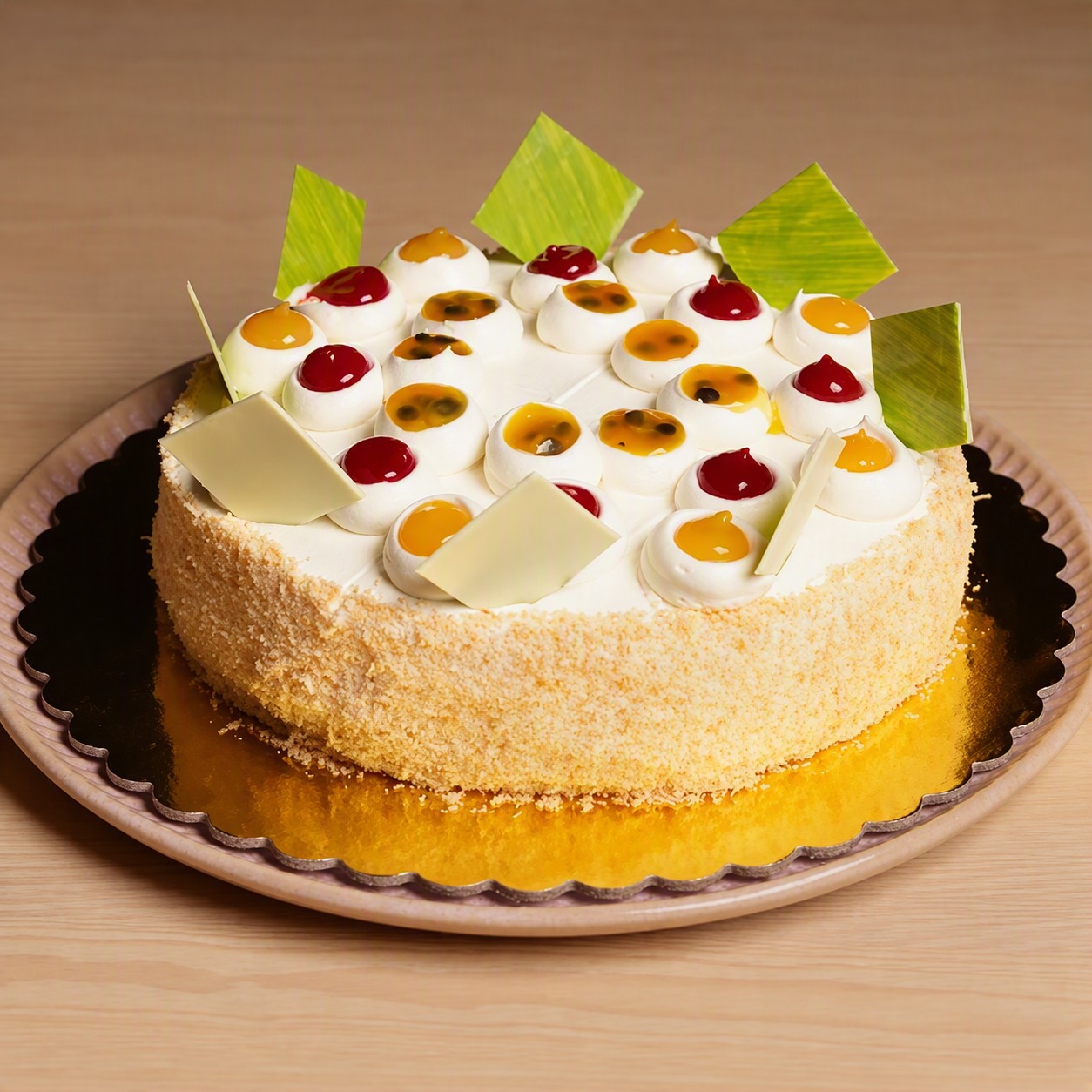 Factoria de Azucar two-tier yellow cake decorated with white icing, meringue dircles with red and yellow filling, and green and yellow marbled white chocolate squares.