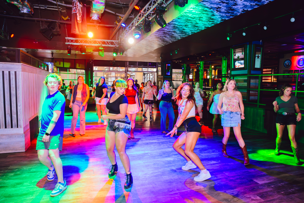 An image of multiple people line dancing at PBR Louisville.