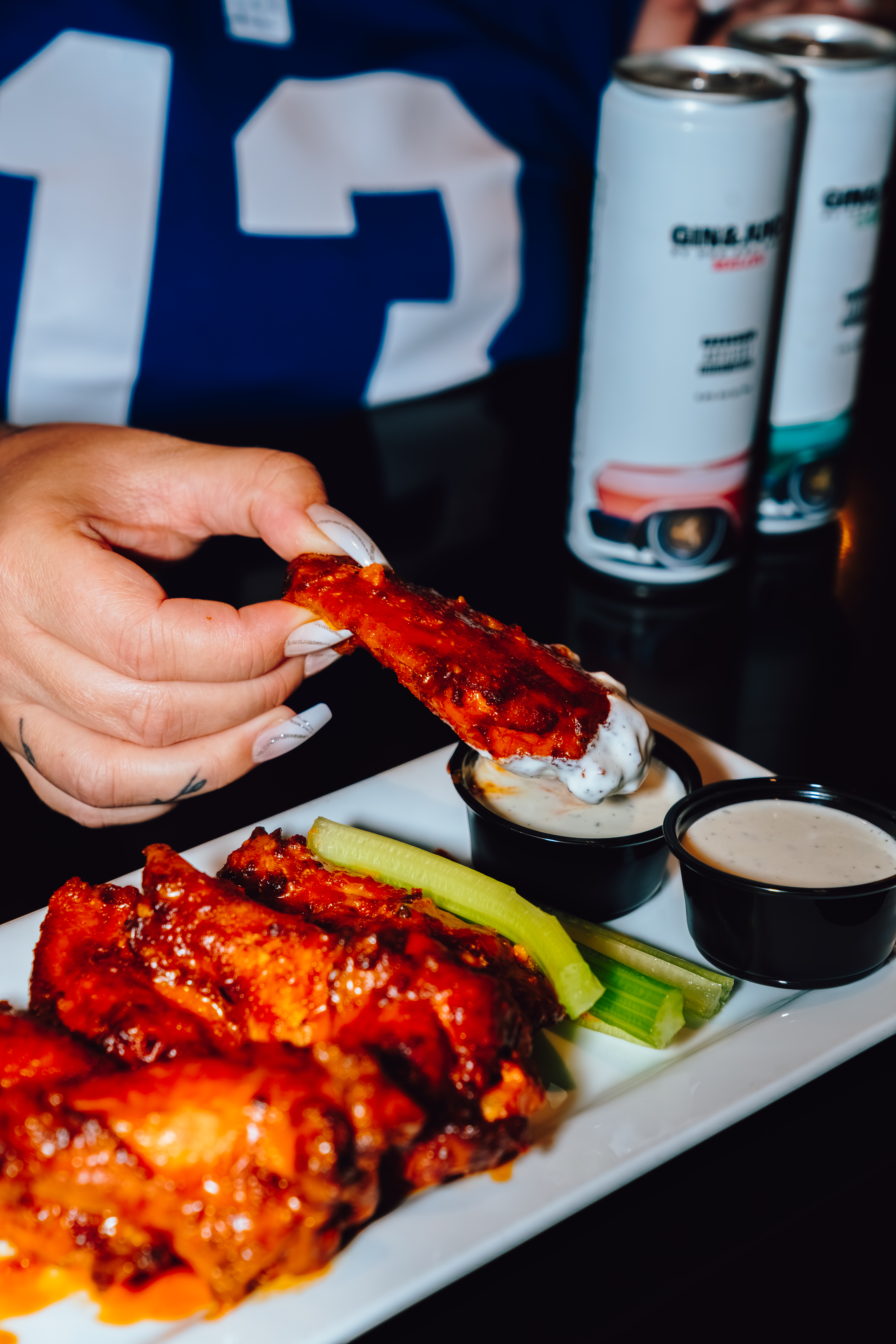 AN image of wings getting dipped into ranch.