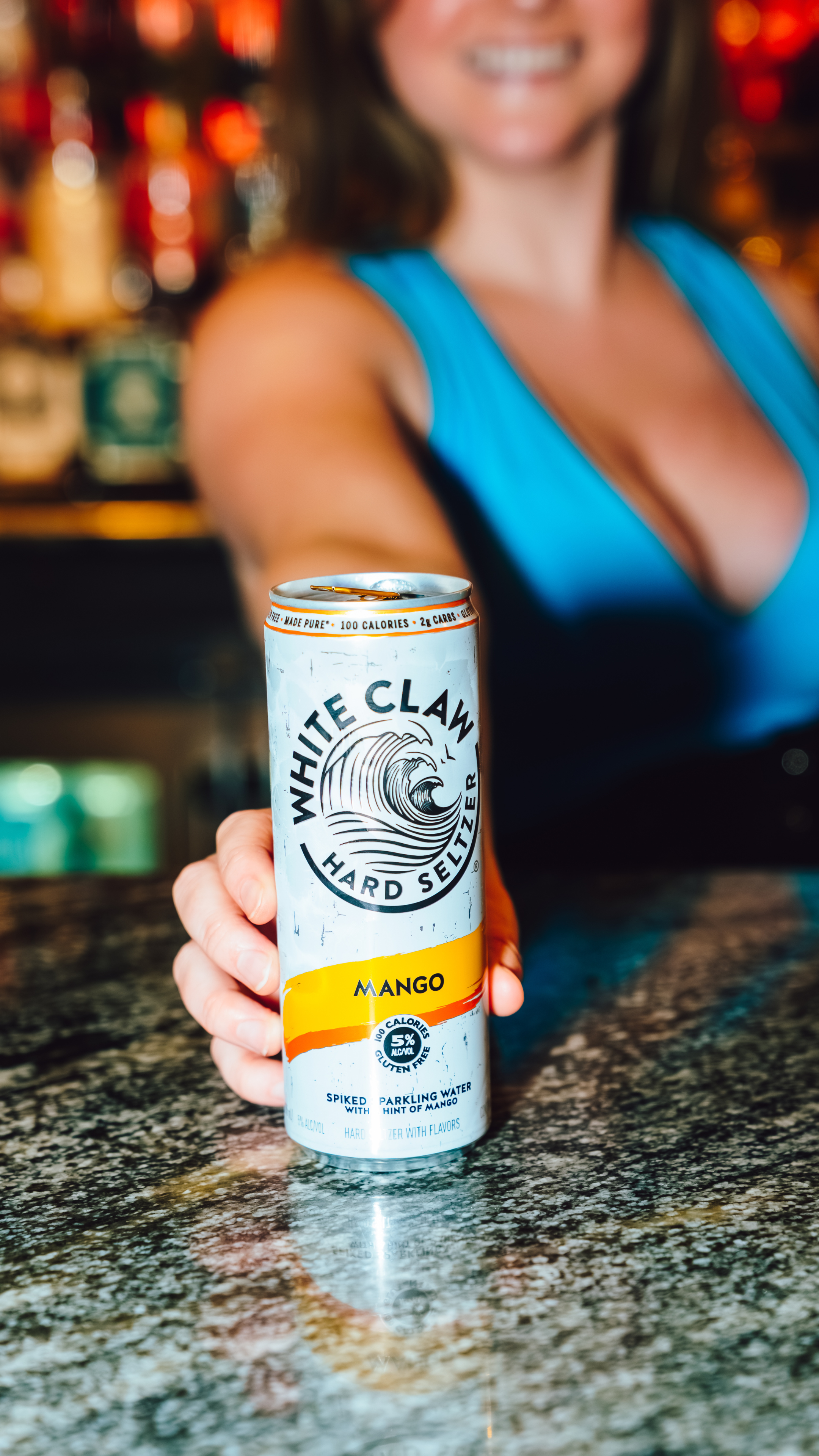 An image of a bartender holding a White claw can.