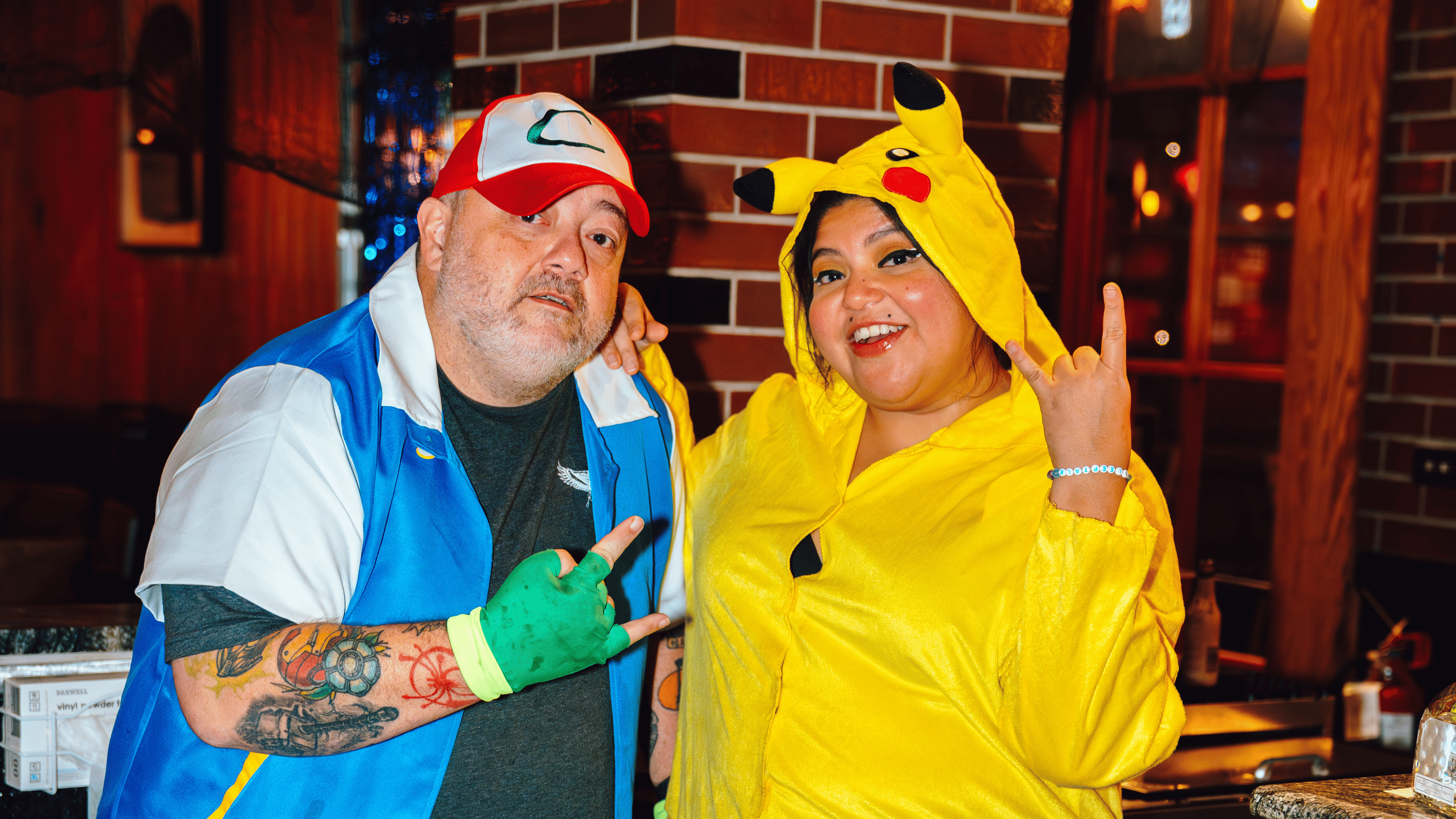 An image of two bartenders wearing Halloween costumes and posing at Guy Fieri's Smokehouse.