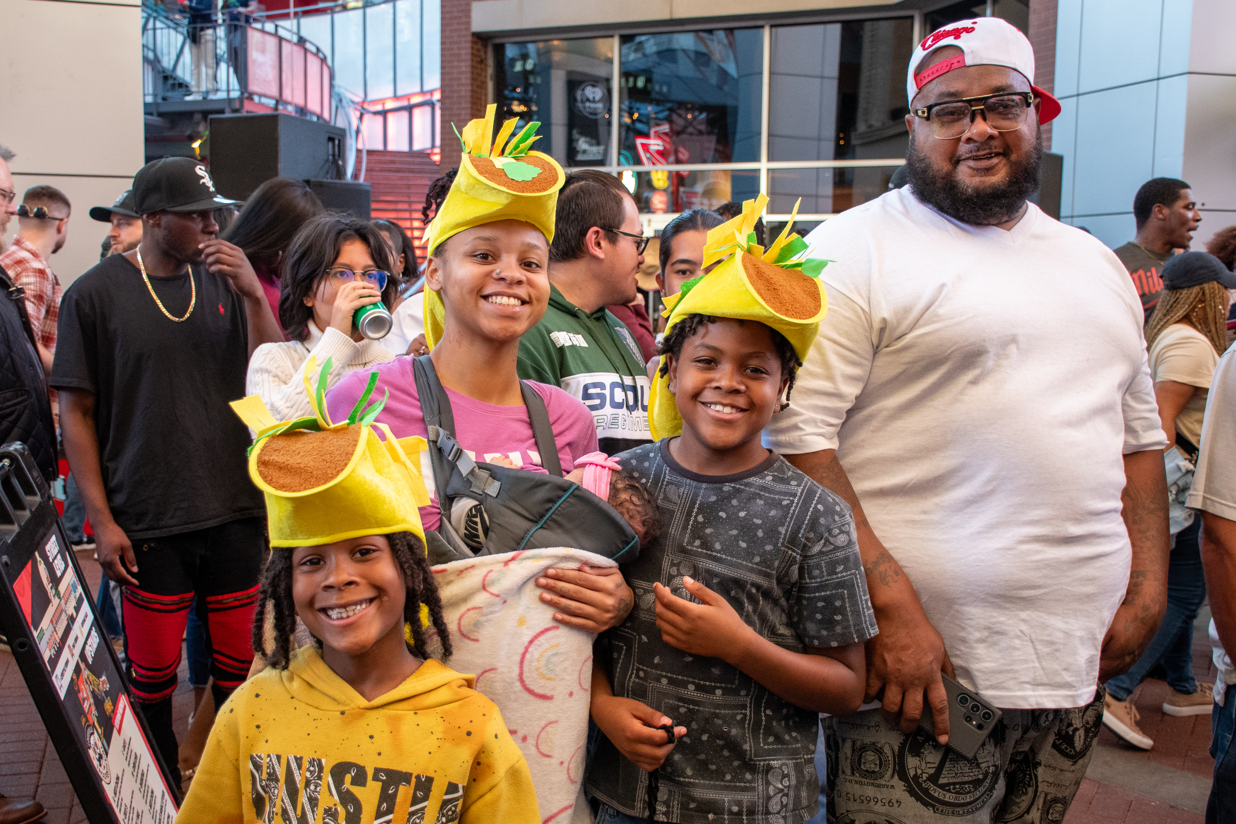 An image of a family with their kids wearing taco hats.