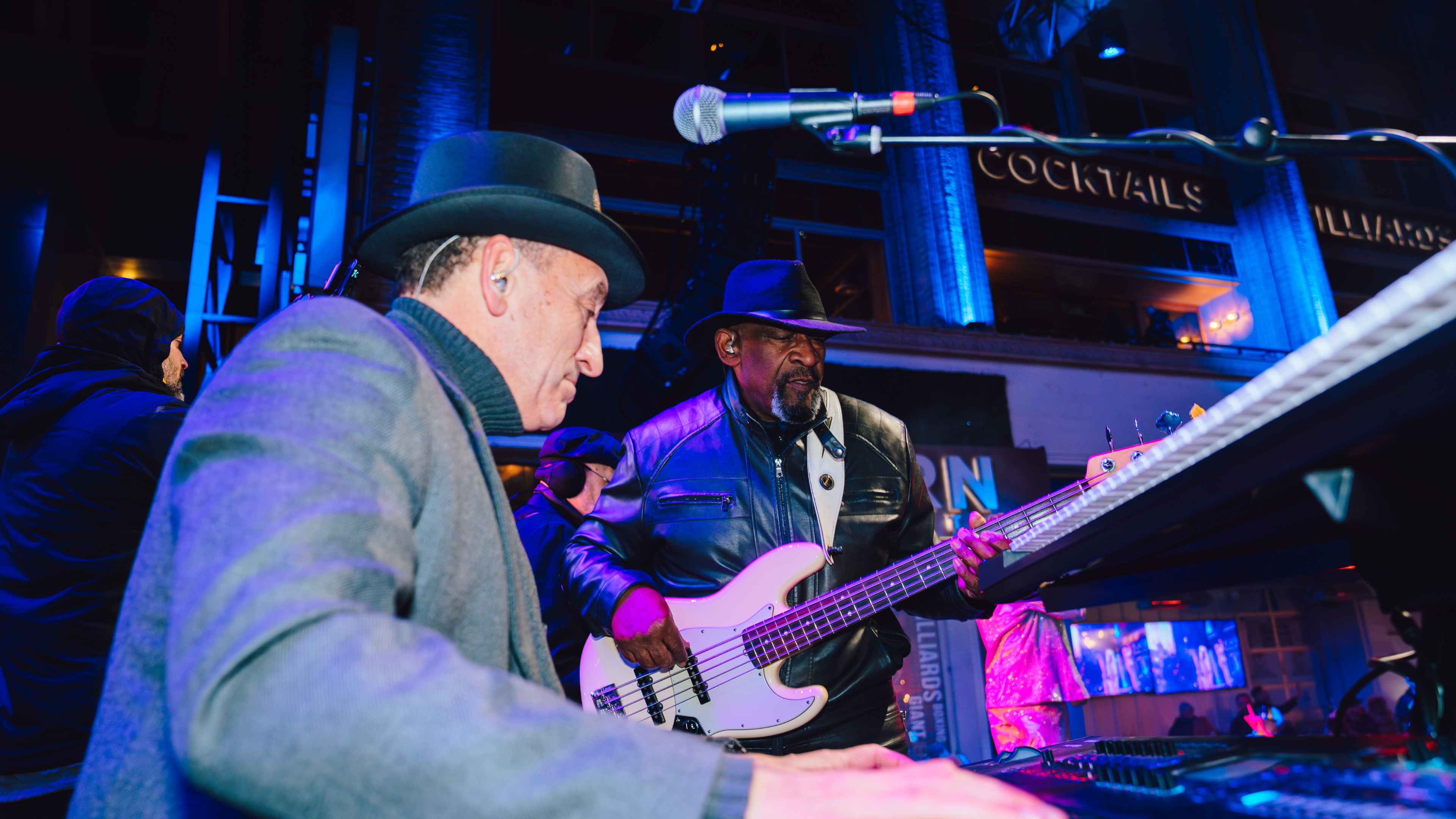 An image of two band members from Soul Circus that are both men and one is playing the piano and another is playing the guitar.