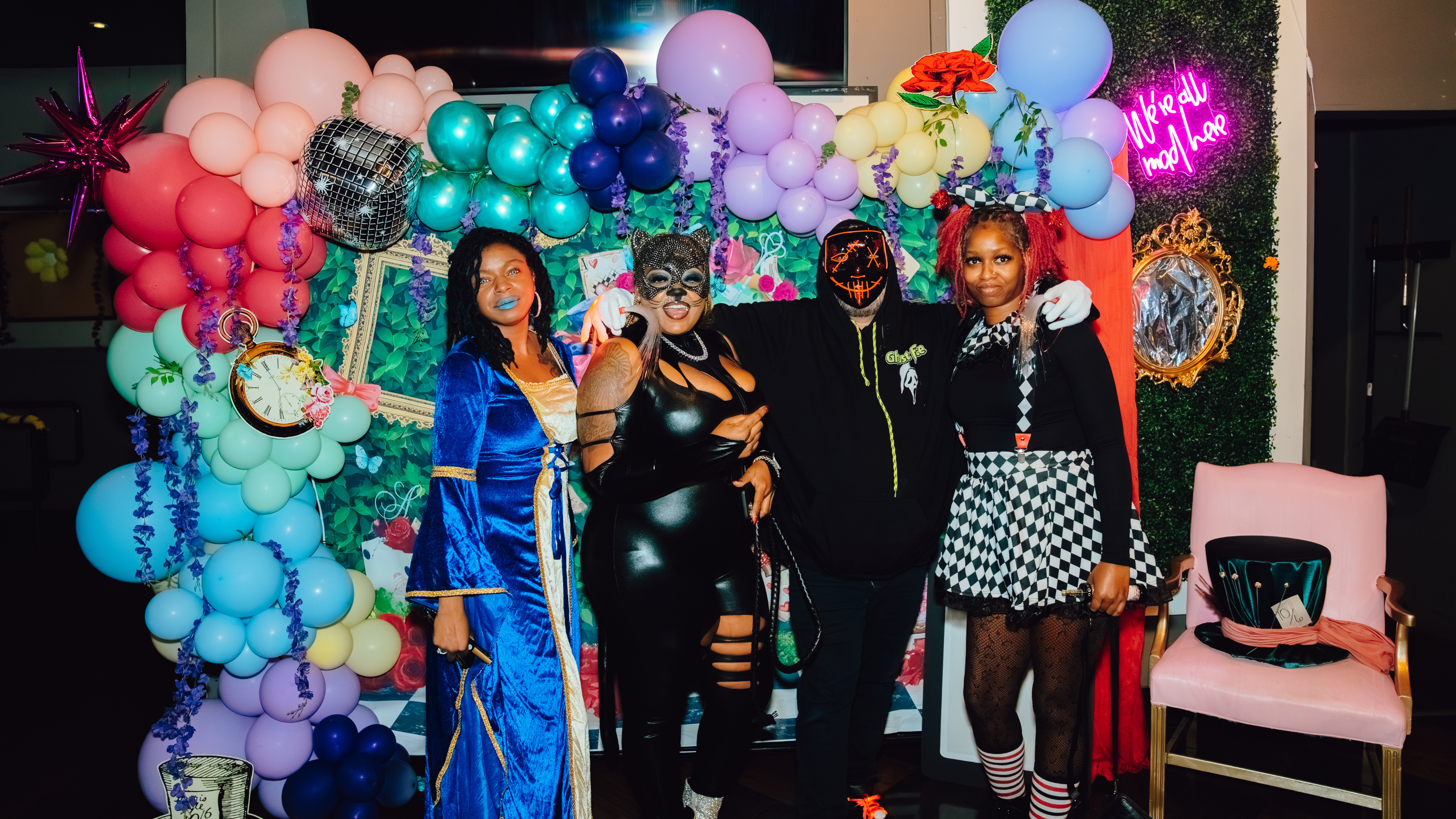 An image of 4 people posing for a picture in Halloween costumes at Sports and Social.