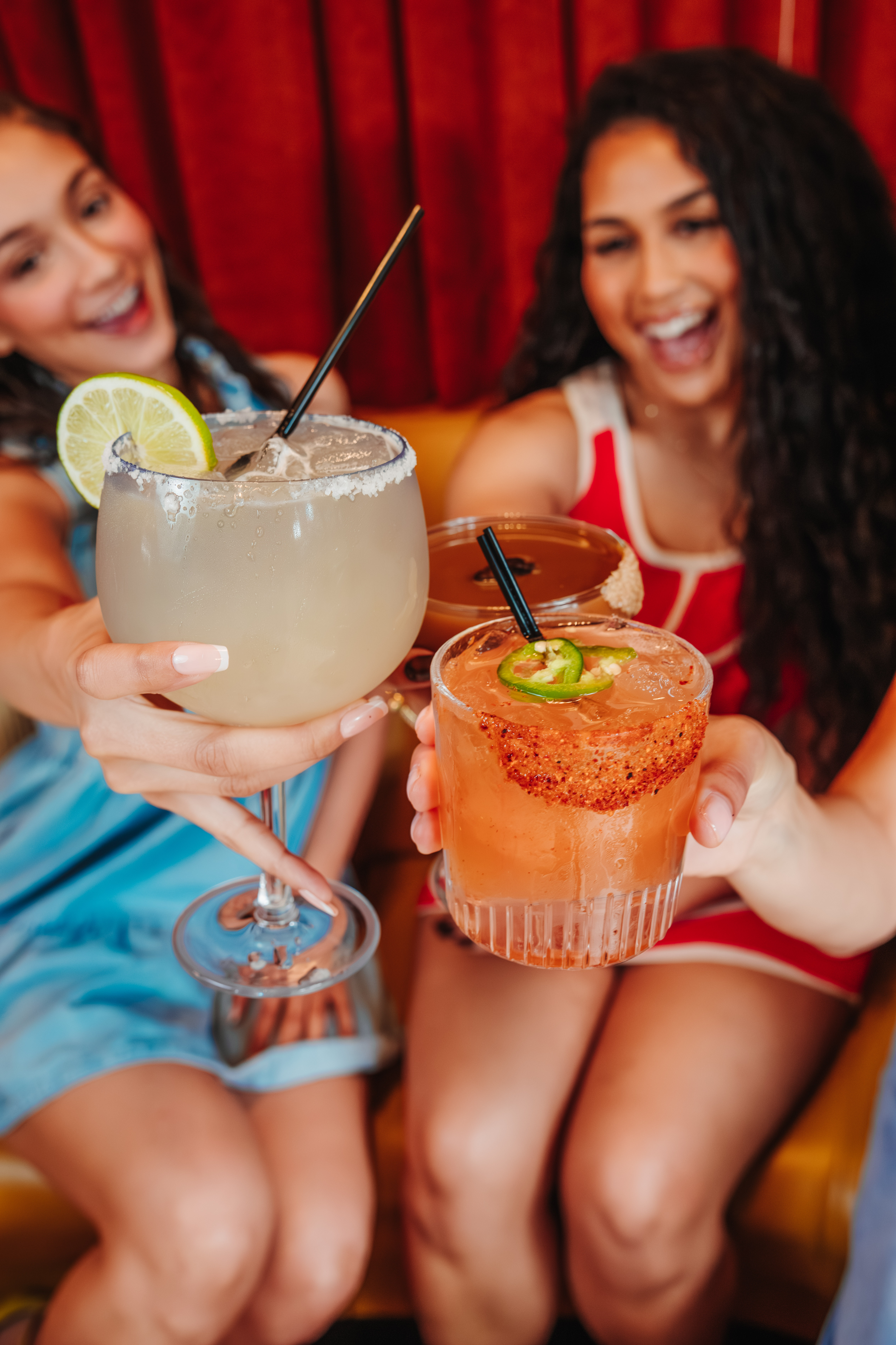 Two friends hold up their margaritas at Besos.