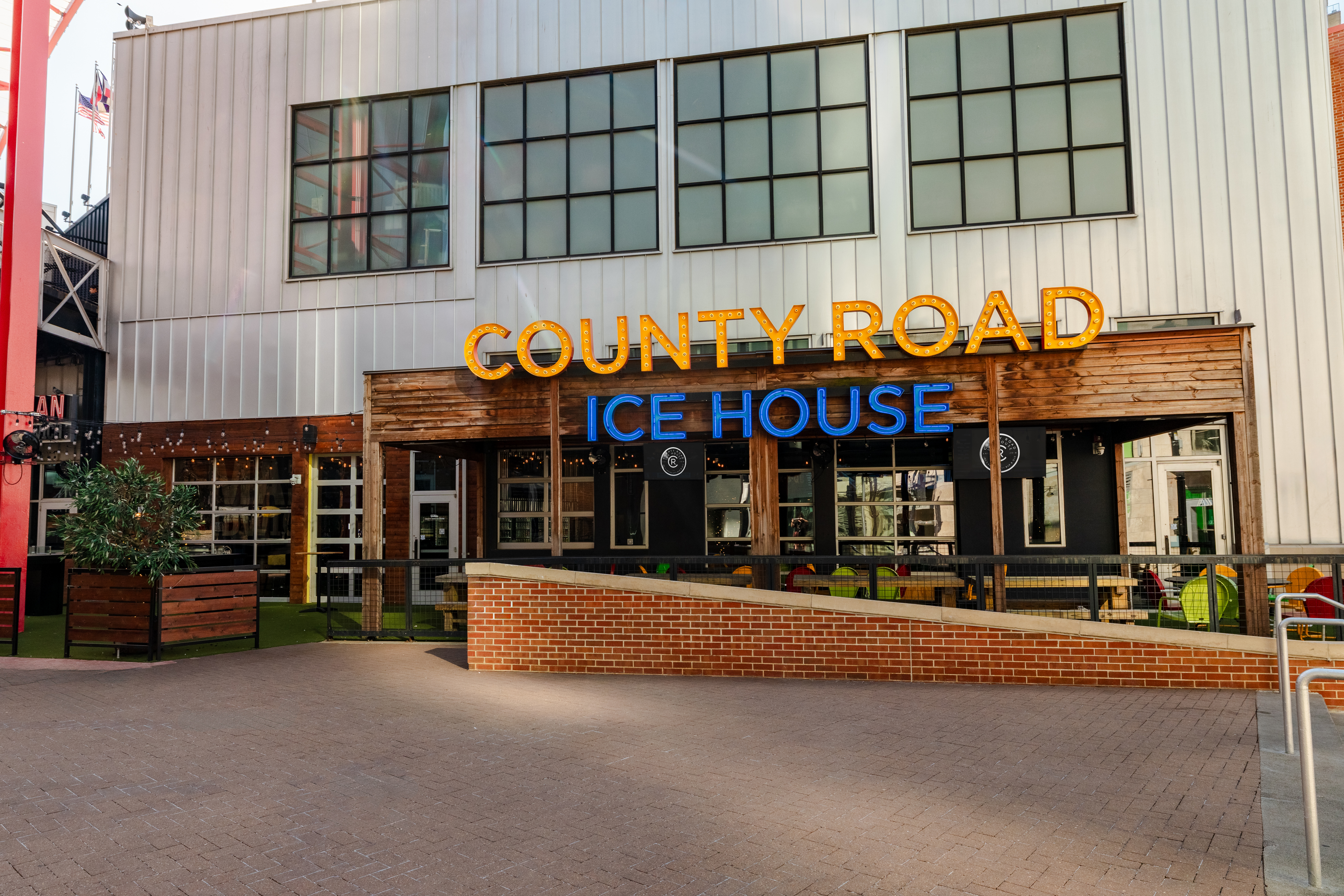 Outdoor patio of County Road with a large yellow and blue LED sign. 