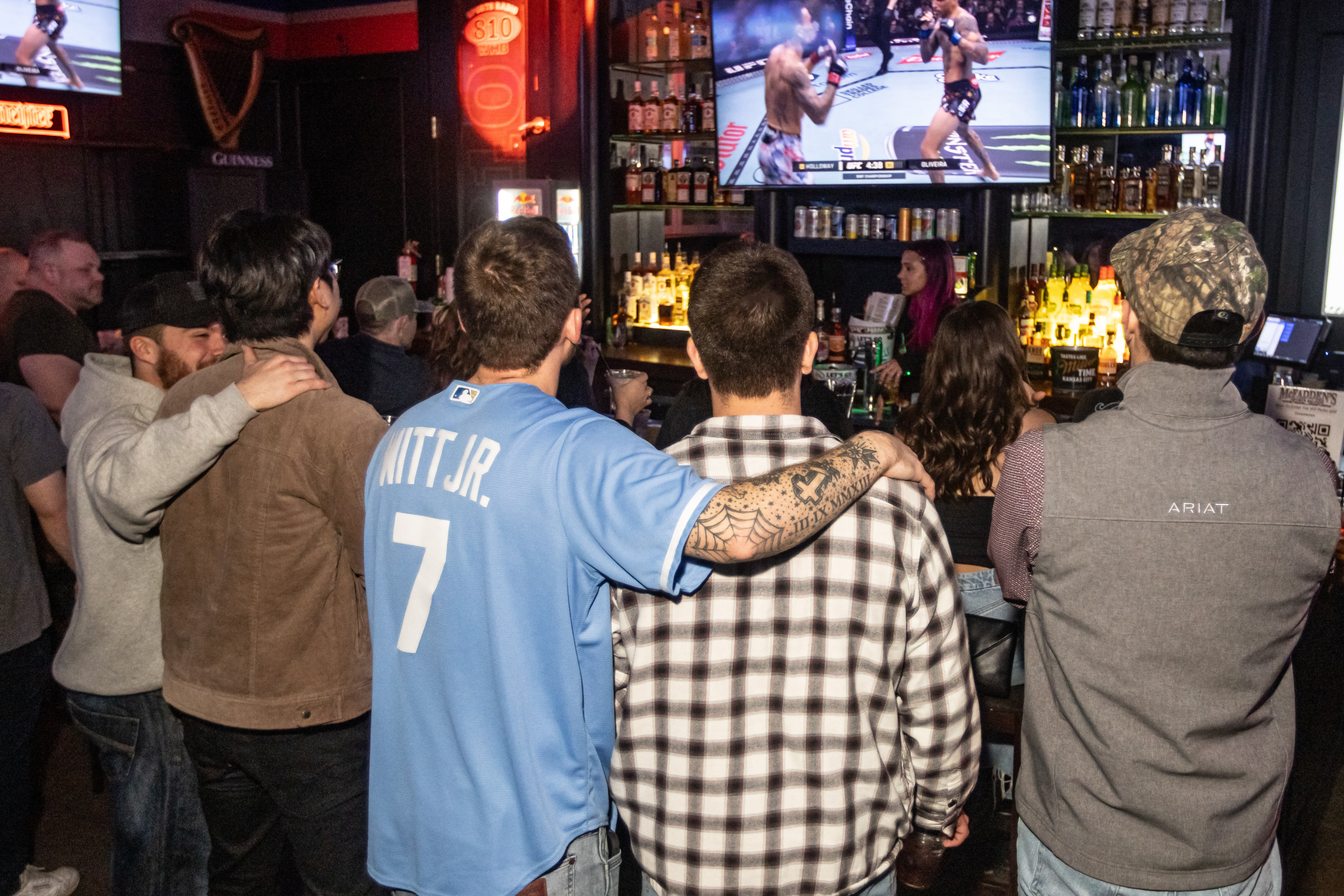 Group of men watching UFC fight on a TV screen