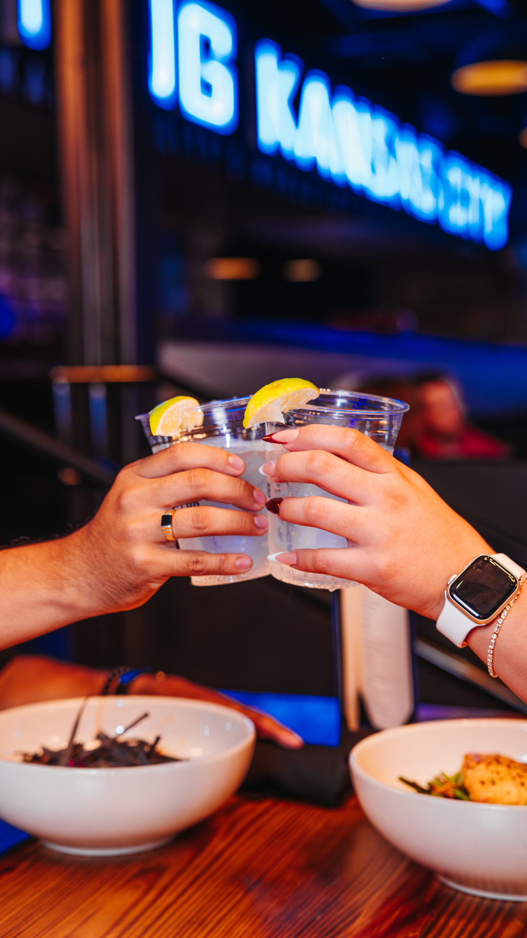 Two hands cheering cocktails