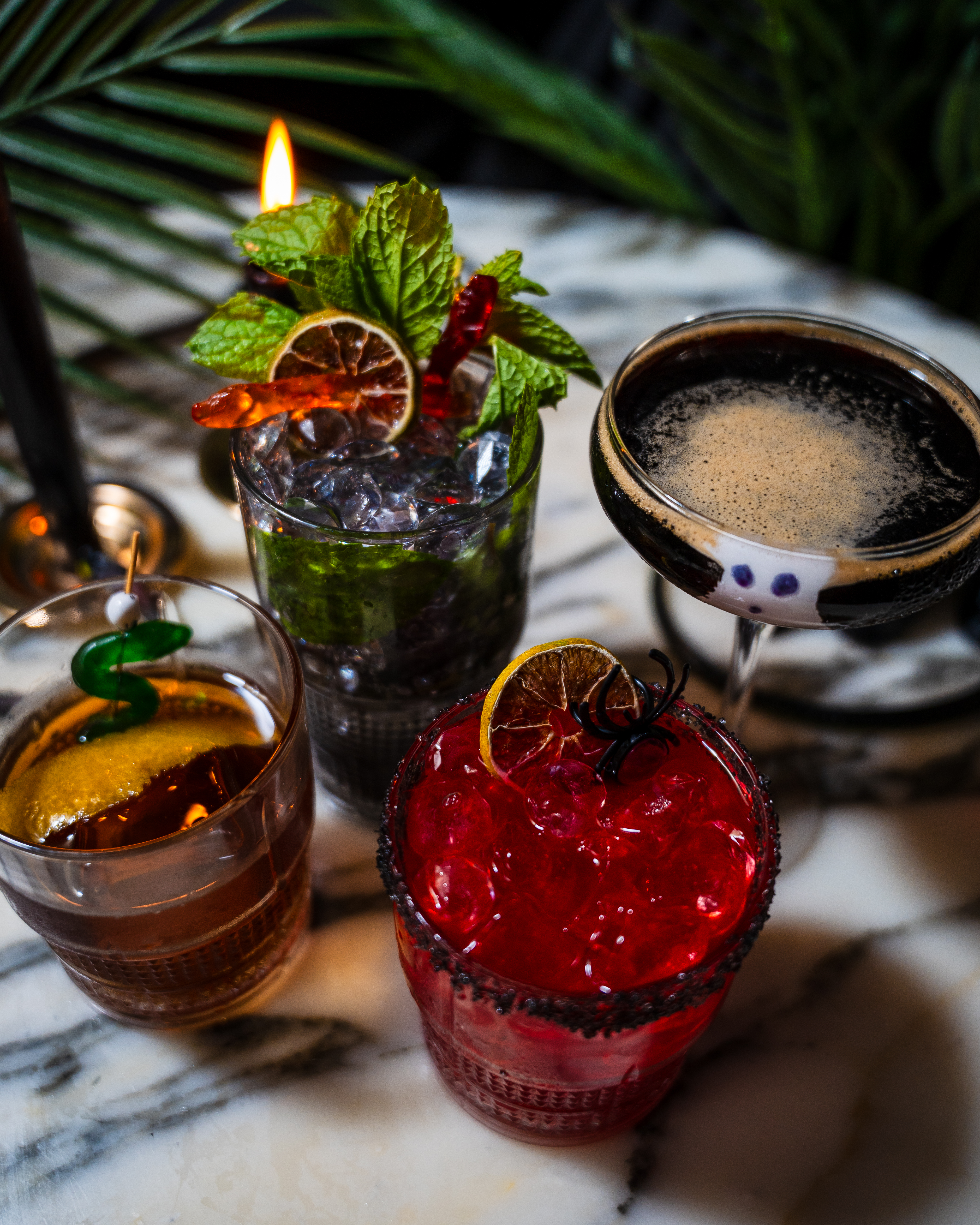 Four spooky cocktails for Paradise Lost at Palm Tree on a marble table.