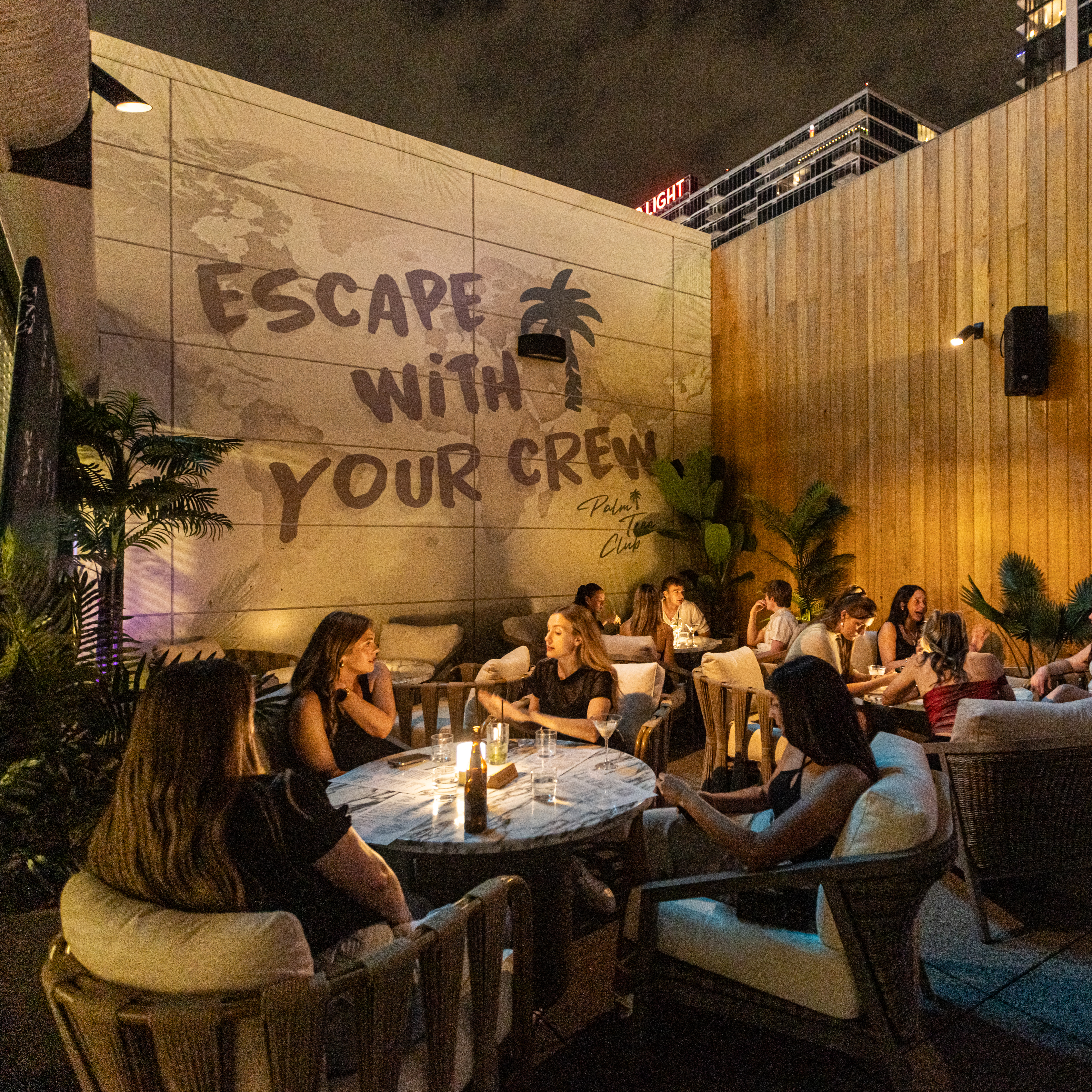 Guests indulge in coastal vibe dining on the Palm Tree KC rooftop.