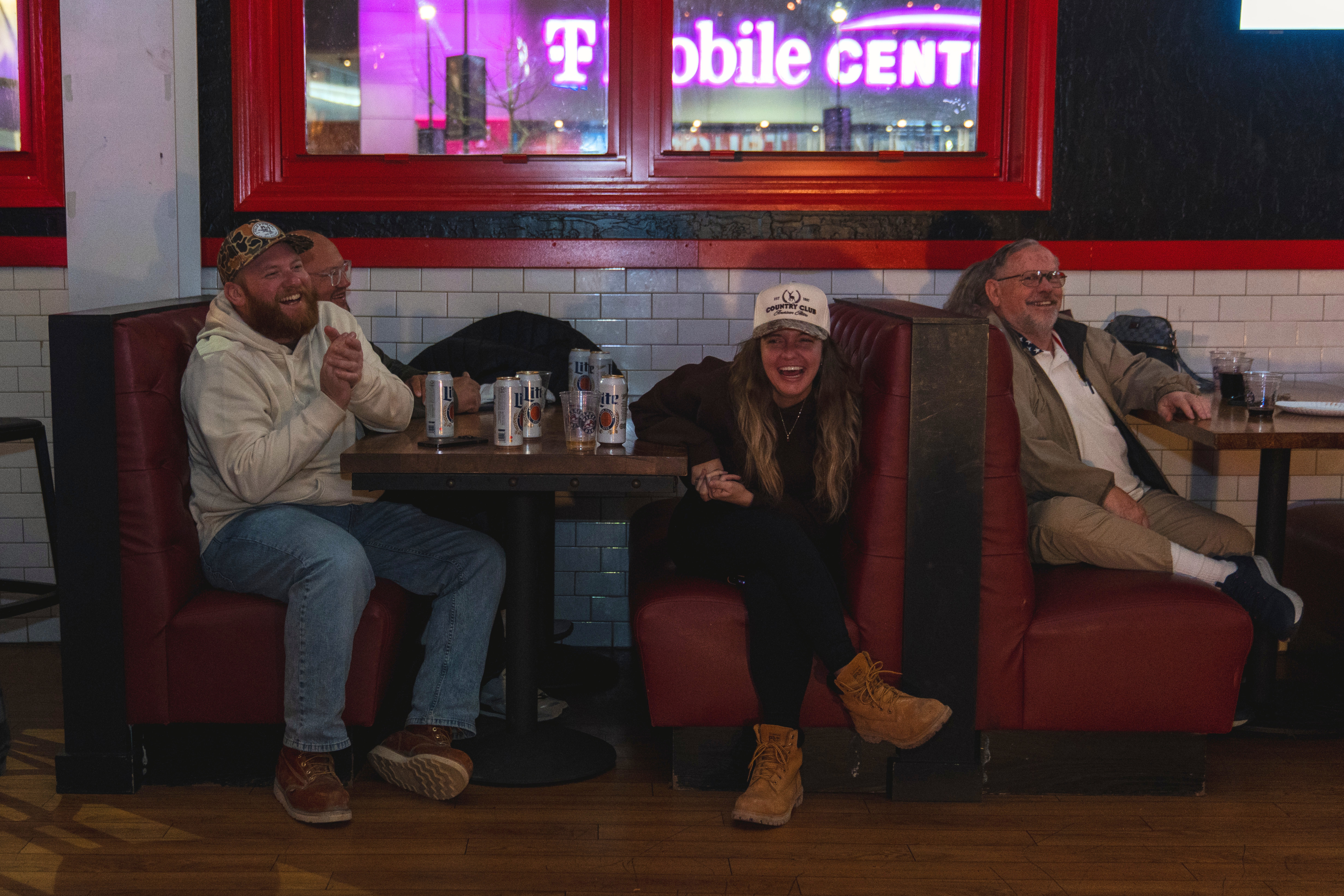 Guests sitting in a booth laughing at Pizza Bar