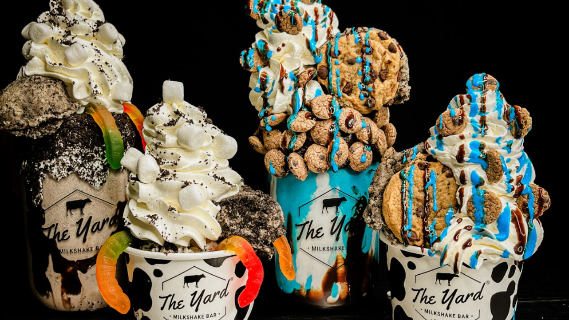 Four over-the-top milkshakes with whipped cream, gummy worms, and chocolate chip cookies from The Yard Milkshake Bar.