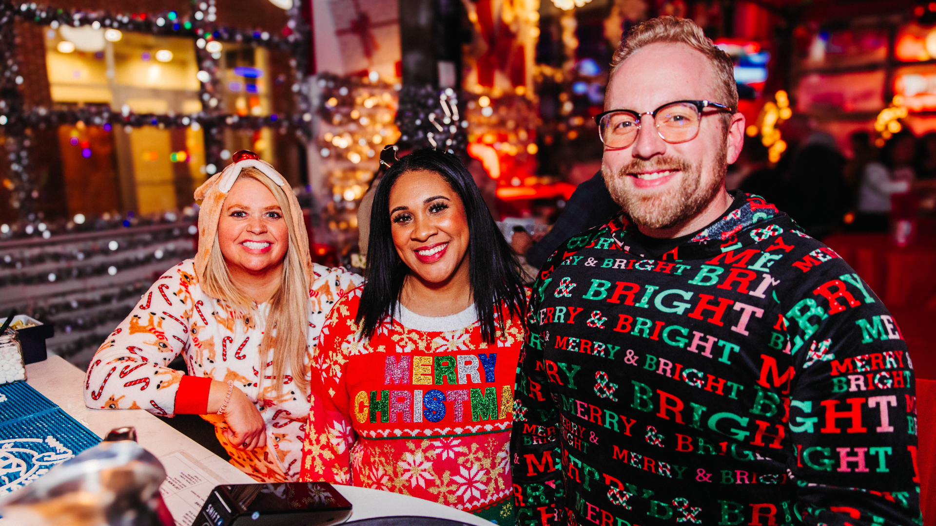 Three people wearing Christmas apparel