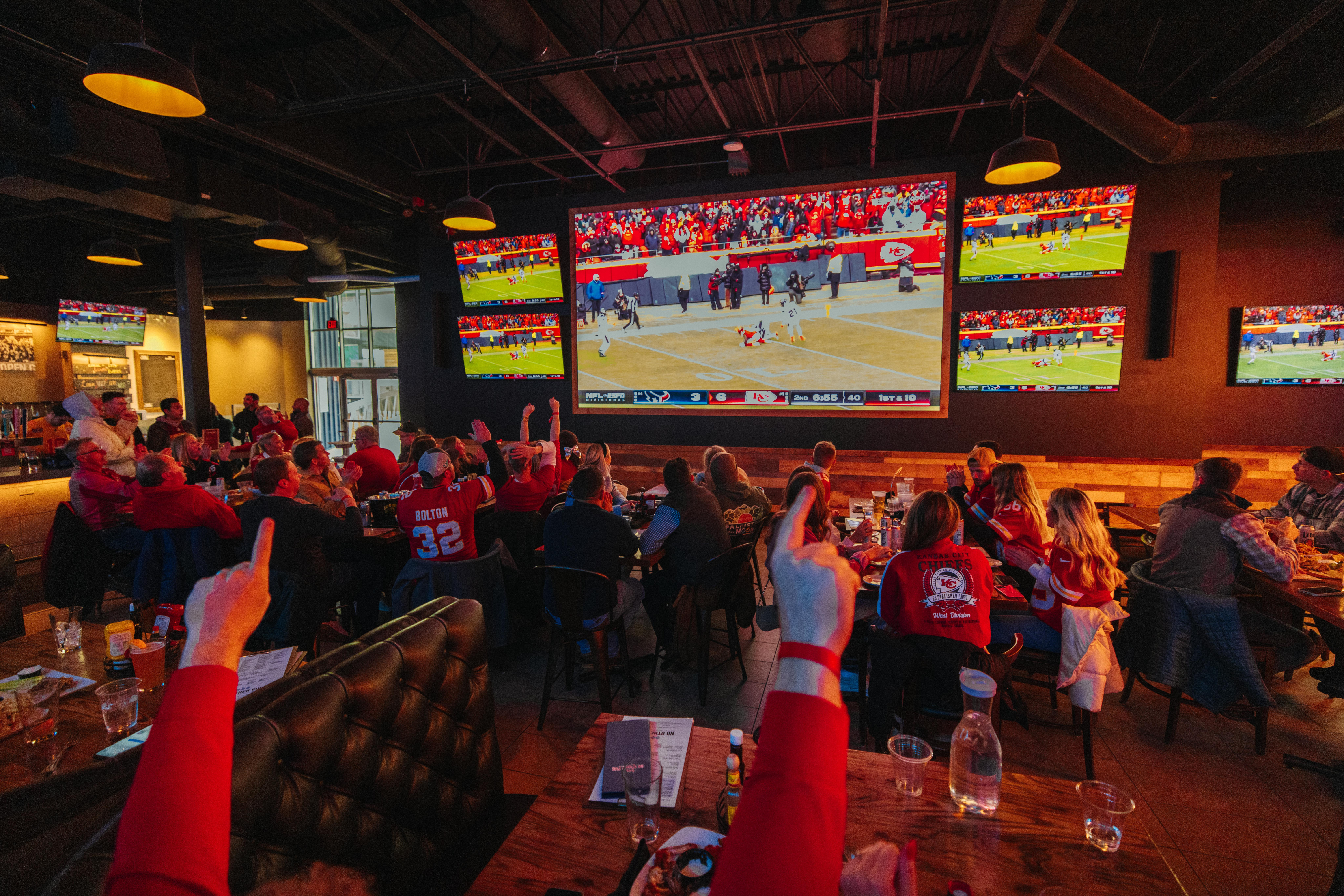 Fans watching Kansas City football game on the big screen TV at No Other Pub
