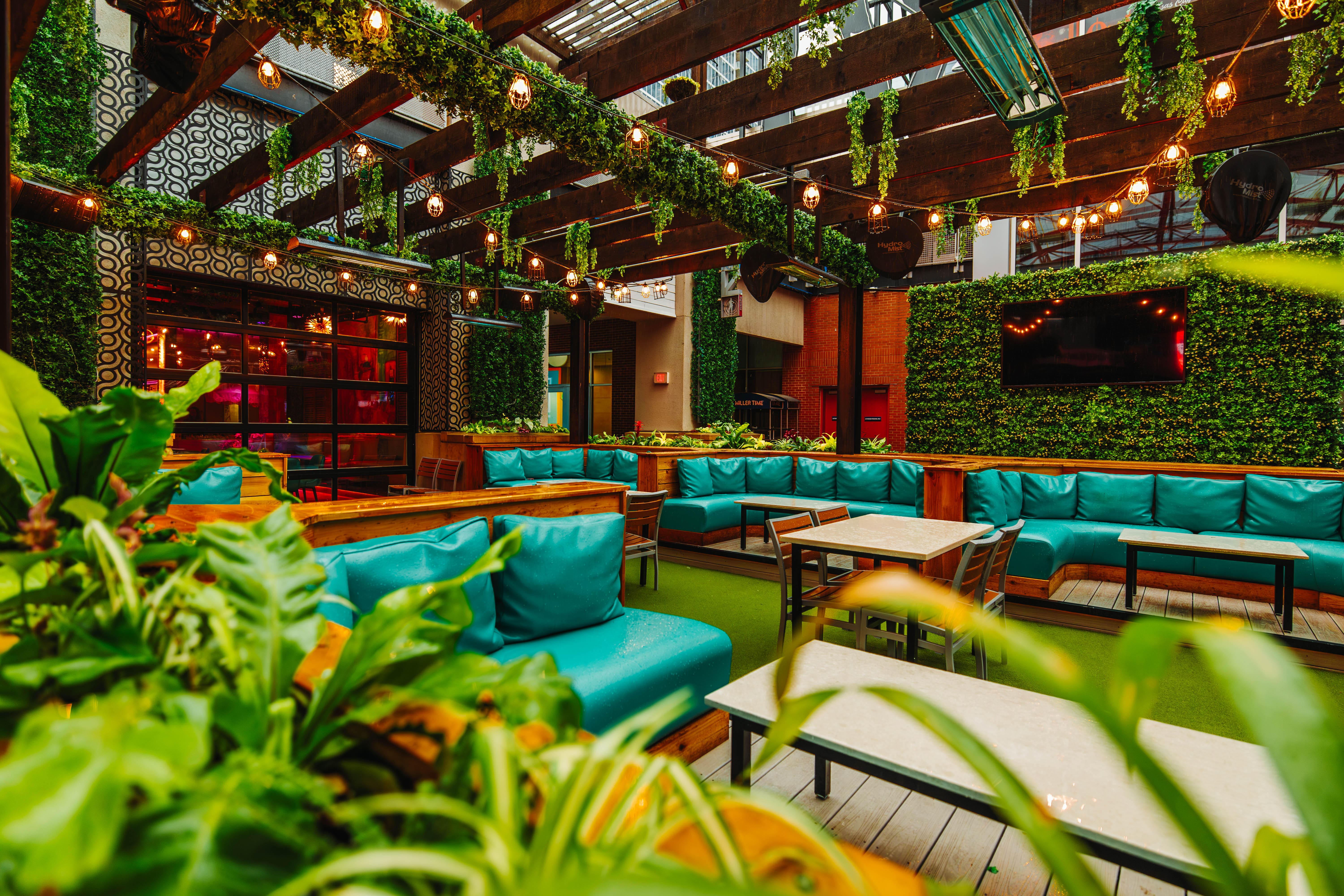 Patio seating at Besos with lush greenery.