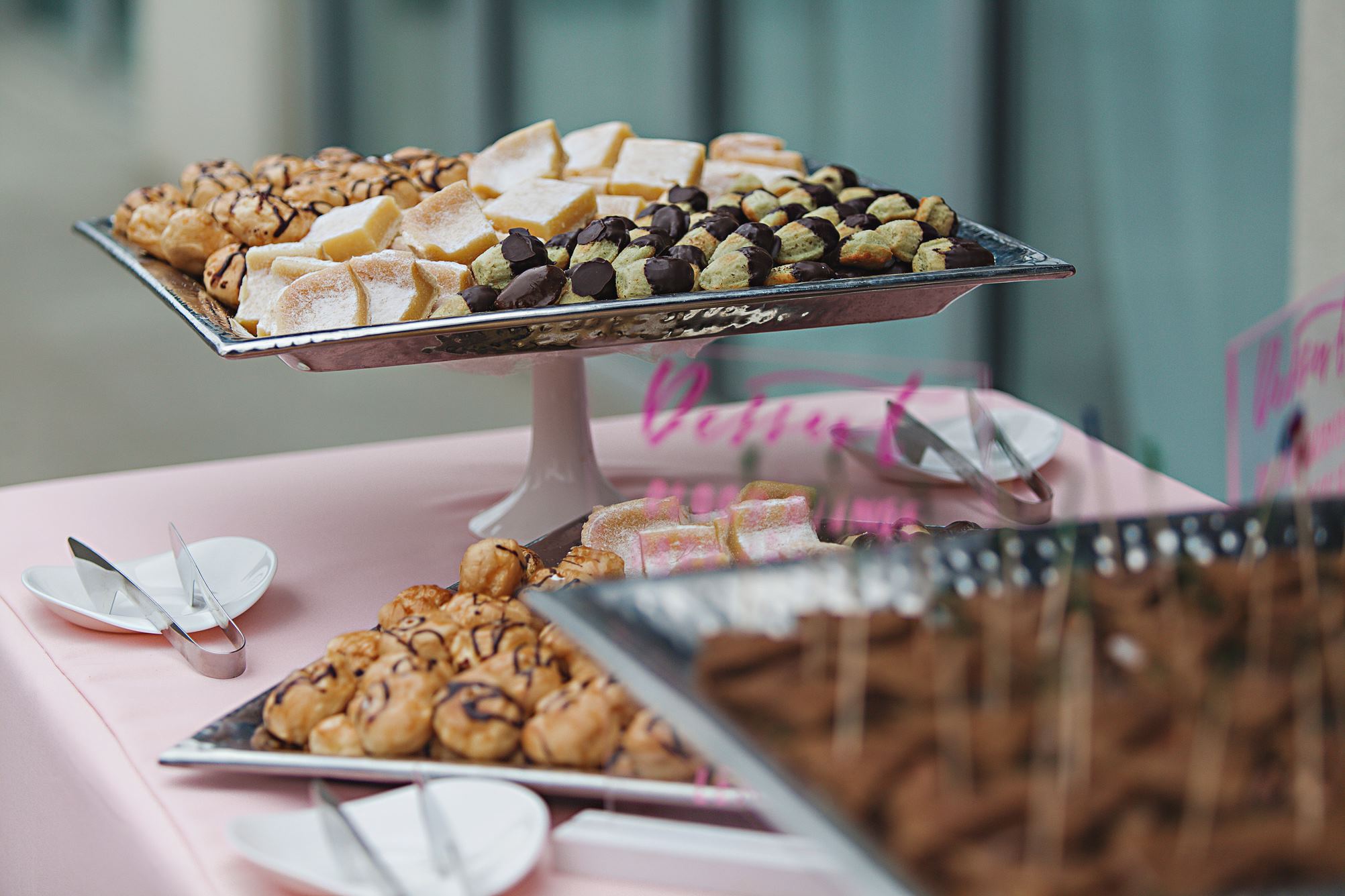 Small catering bites presented on a table with pink linens.