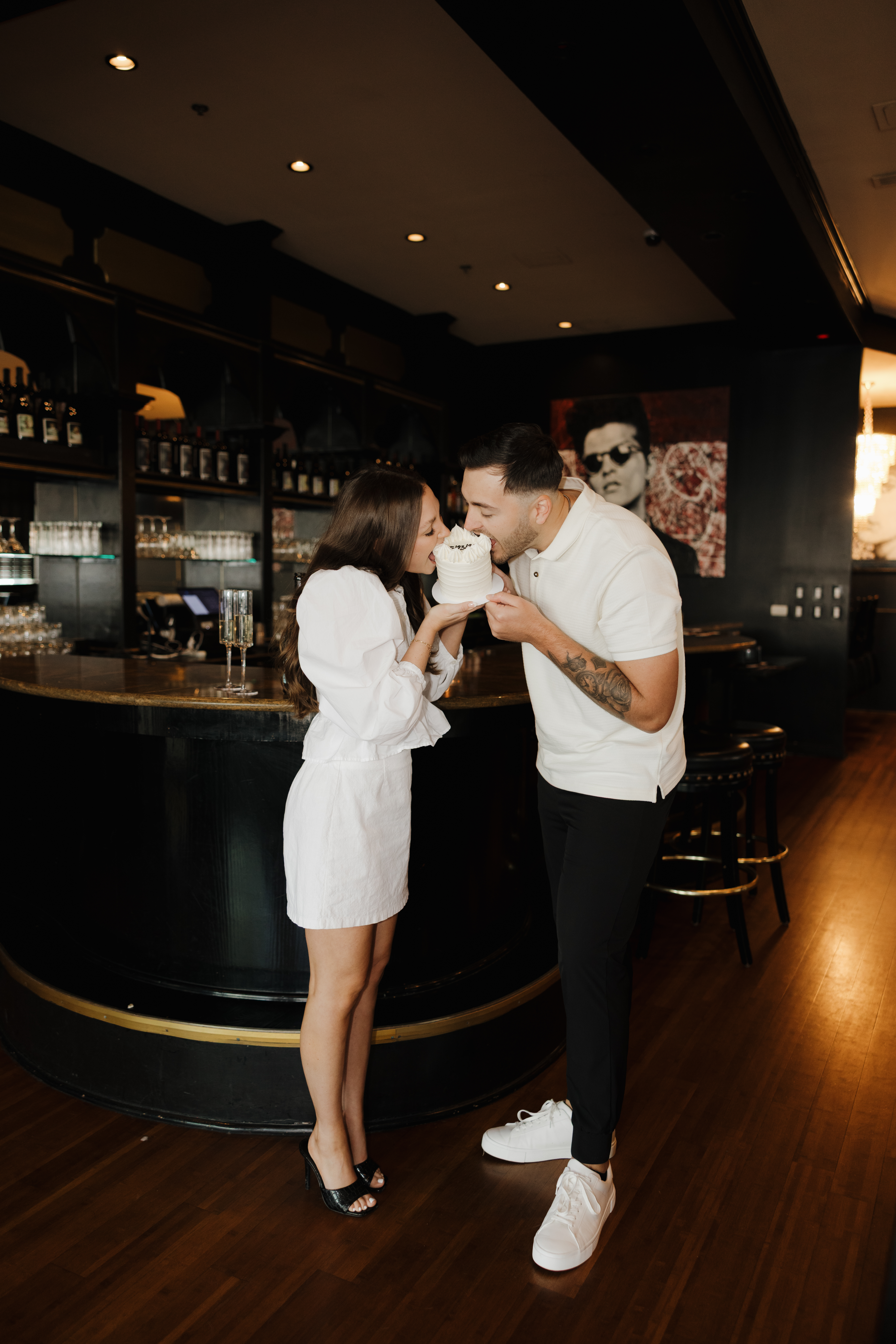 A couple in The Kill Devil Club holding a white cake.