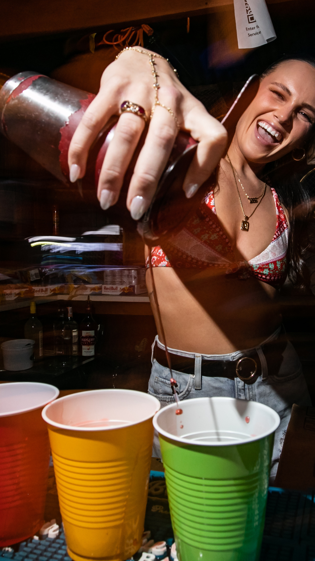 Bartender pouring drinks in red, yellow, and green Solo cups