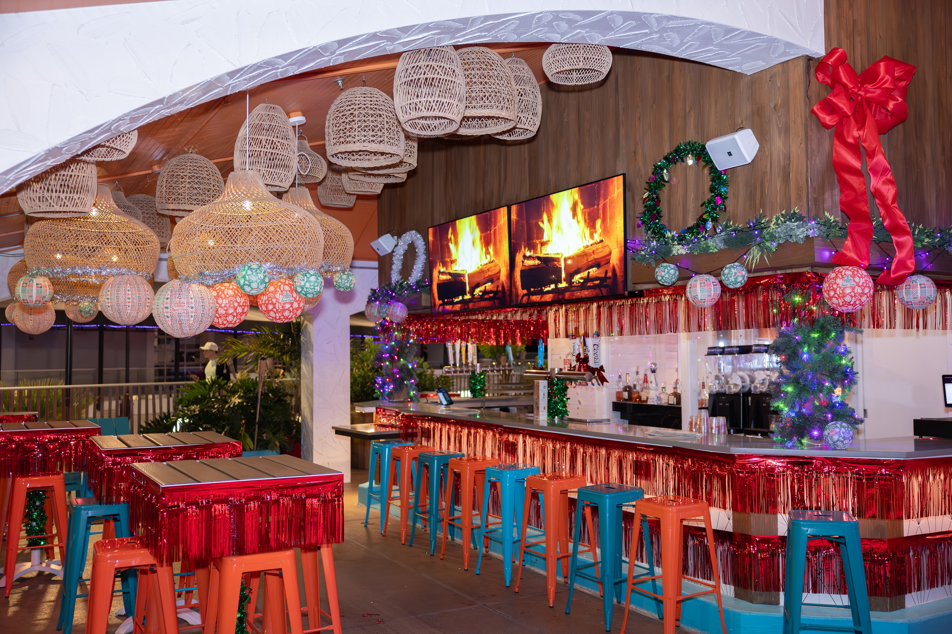 Shark Bar outdoor patio festively decorated for the holidays with large red bows, wreath, garlands, and lights.