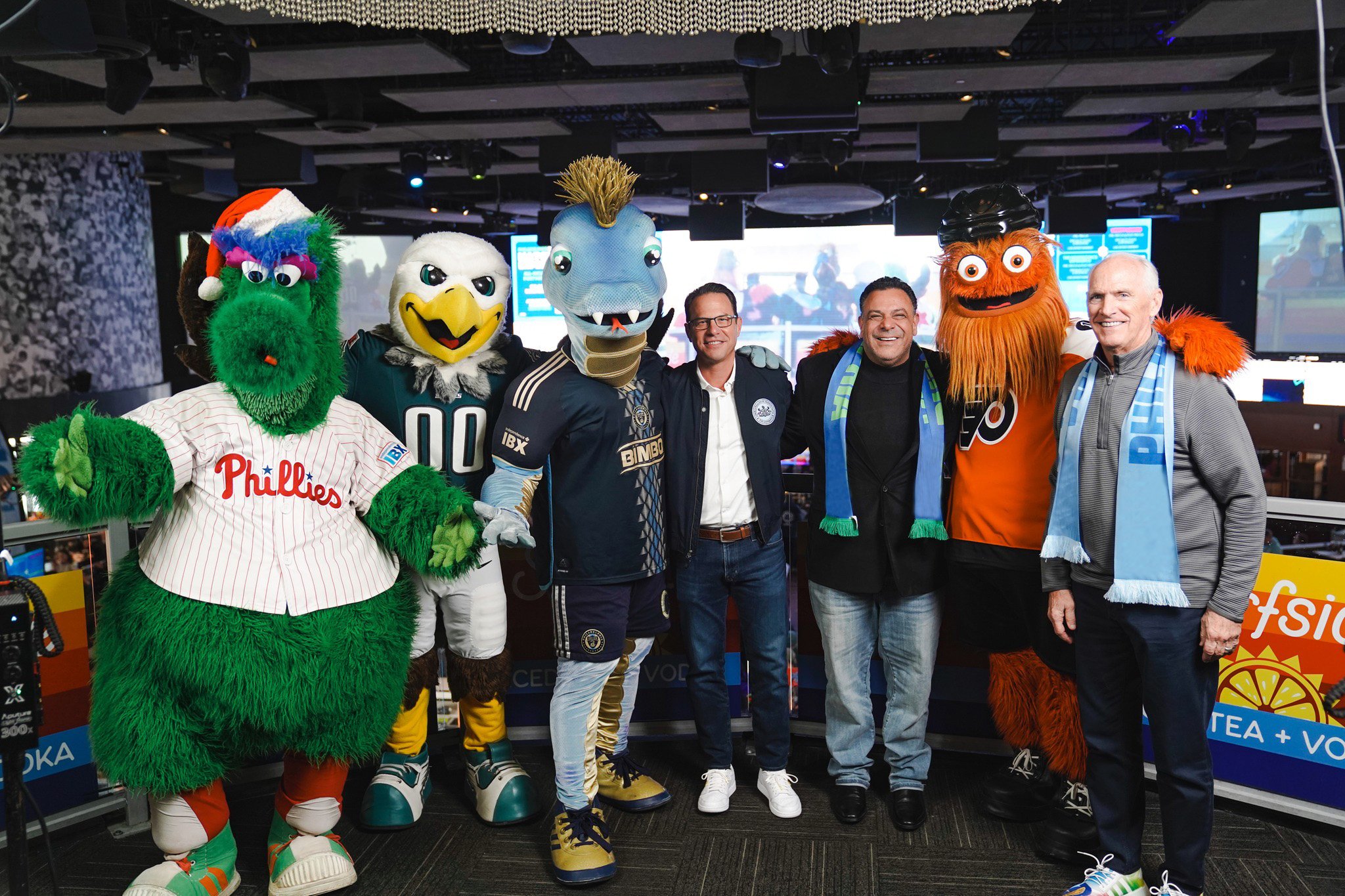 Philly sports mascots posing with fans.