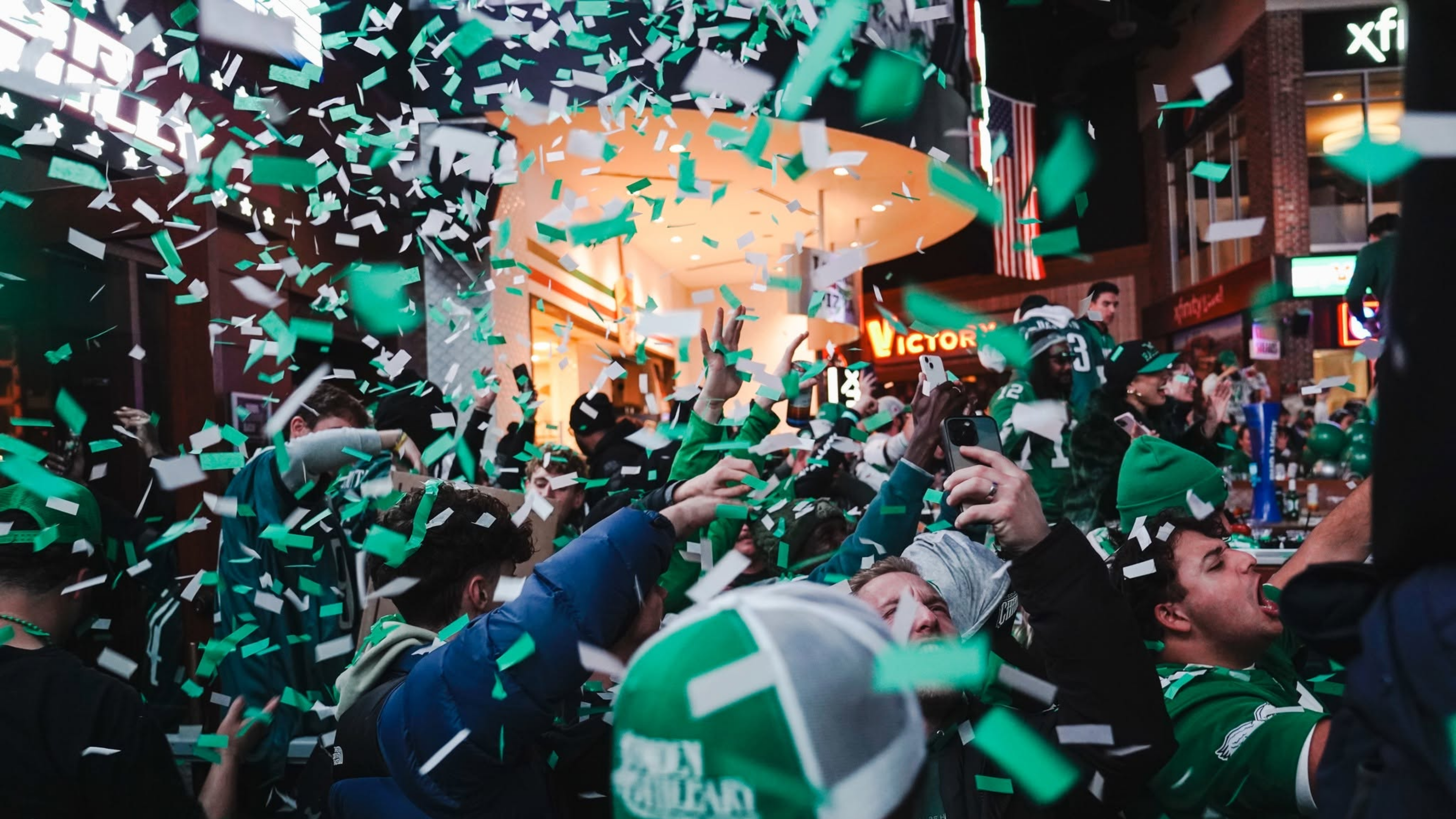 Crowd cheering green confetti