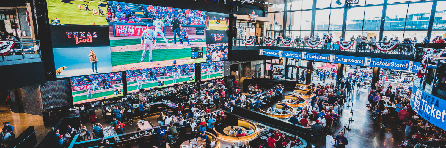Wide shot of Texas Live! Area dining area, bar, and large-screen TVs.