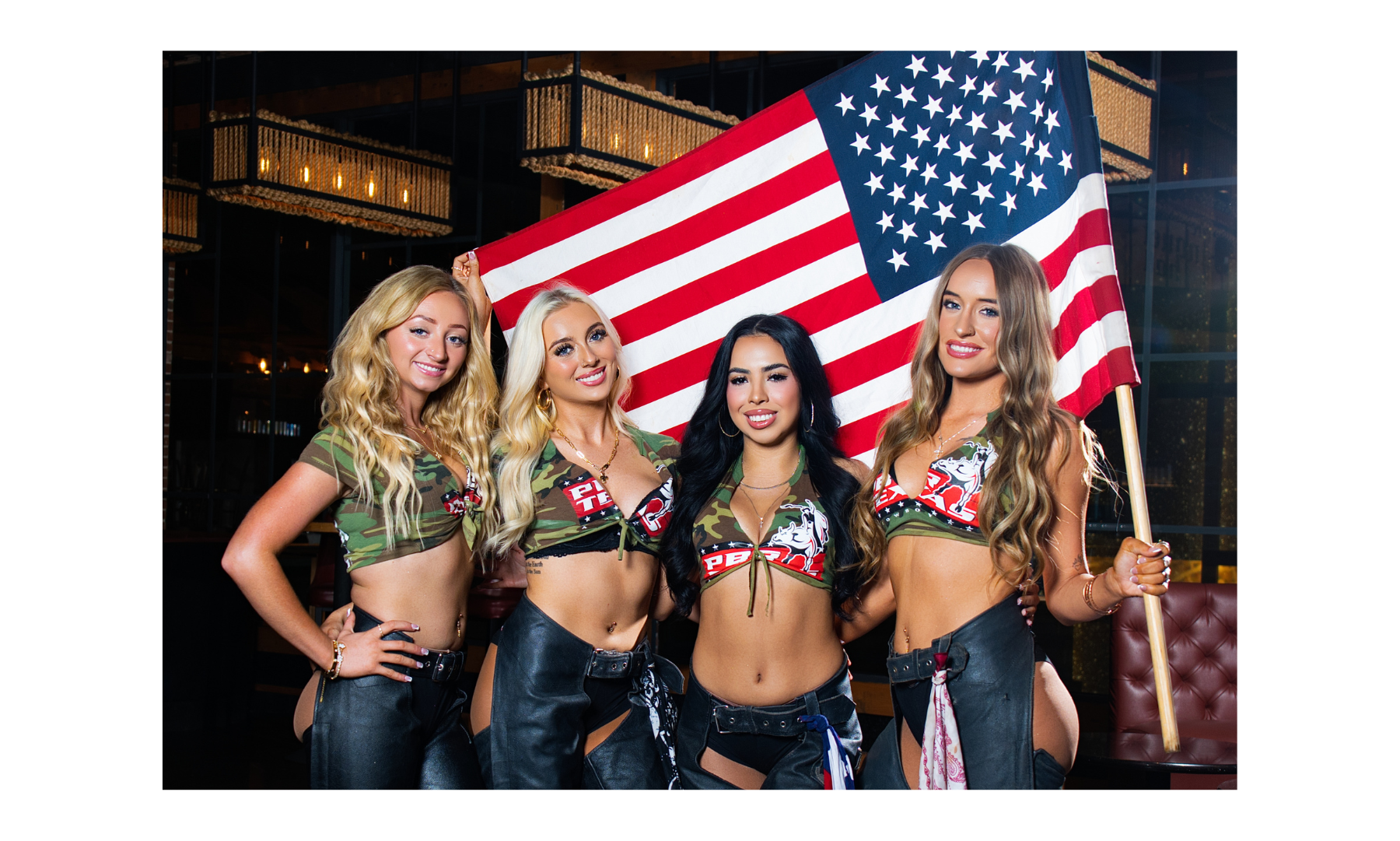 PBR Texas girls posing for an image in matching work outfits in a VIP booth