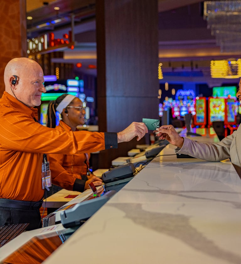 live employee handing a rewards card to customer