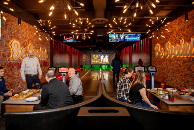Group of people enjoying Sports & Social's Bowling Alley