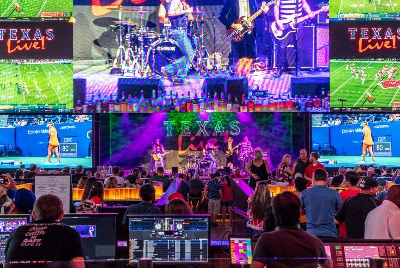 Fans enjoy the best of both worlds inside Texas Live! As a band plays center stage, games air on LED screens behind them.