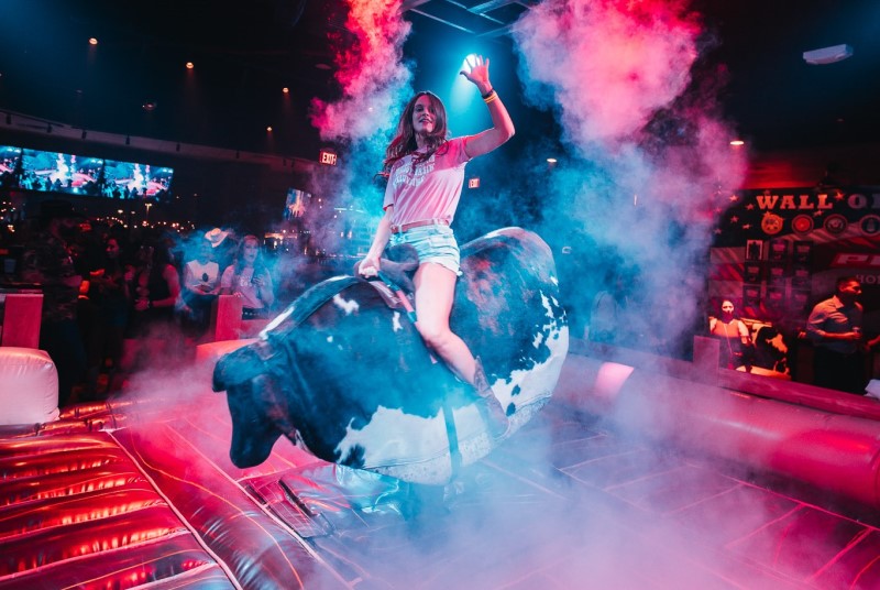 Woman riding a mechanical bull at PBR Cowboy Bar Nashville Live!