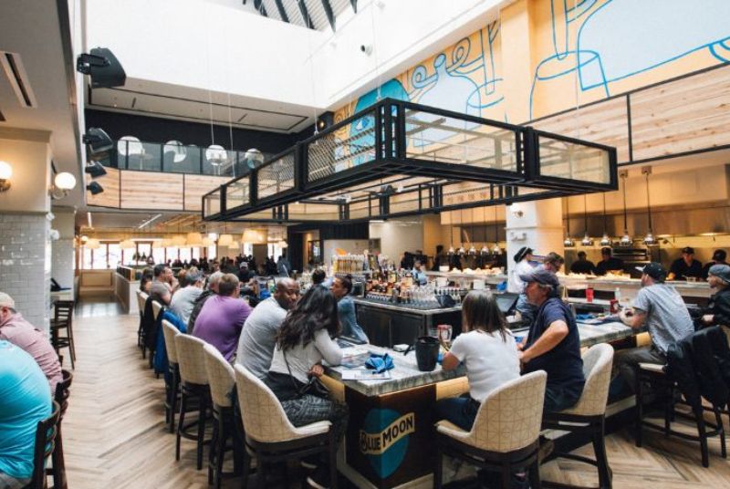 At the Blue Moon TapHouse bar, customers enjoy the bright skylight and exposed kitchen, where their food will soon be ready!