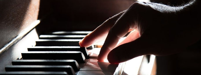 piano keys and one hand playing