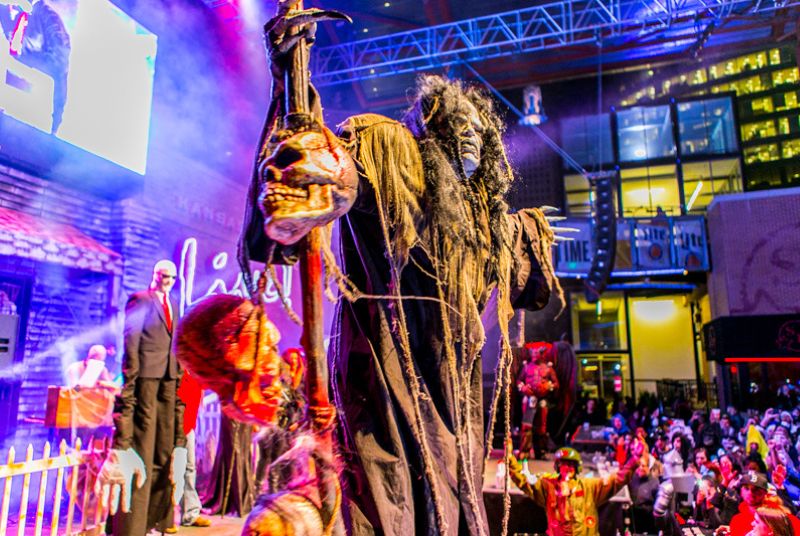 Skulls hang from the staff of this Halloween fiend as he looks over the crowd.