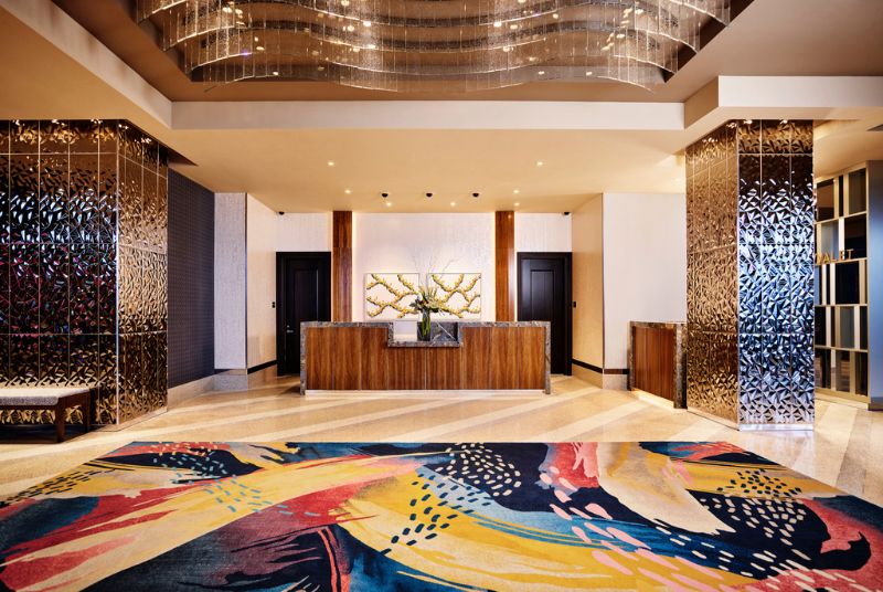 The lobby has stunning ceiling art of flowing glass ribbons while hammered gold support beams border the check-in area. 