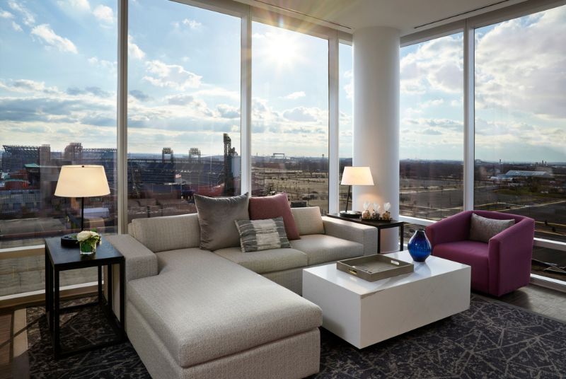 A hotel suite's cozy sitting area has picture windows overlooking the Philadelphia Phillies Citizens Bank Park.