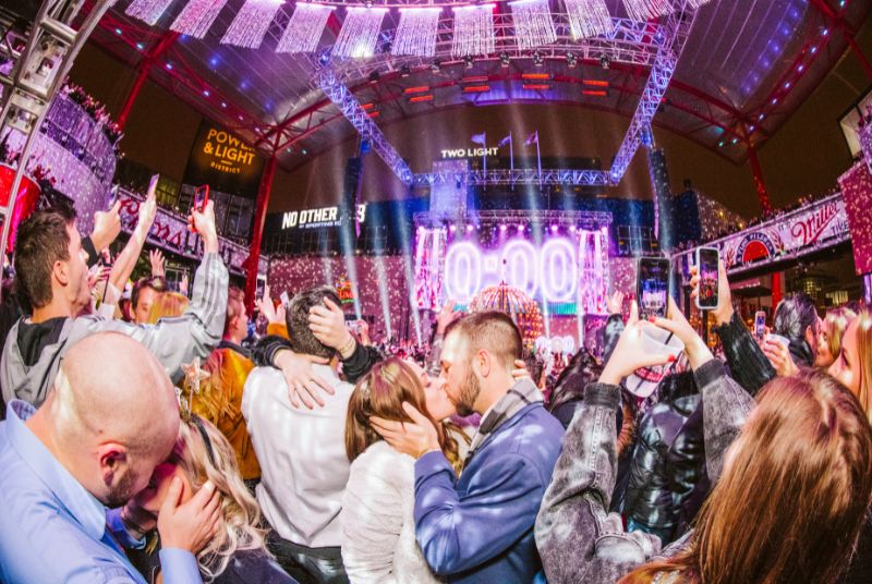 At a sparkly New Year's Eve celebration, couples throughout the crowd kiss as the countdown clock hits zero!