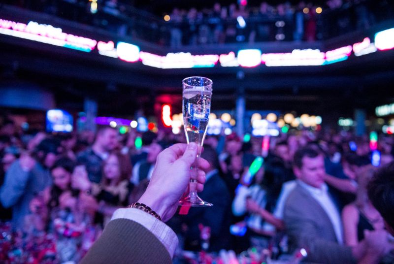  A New Year's reveler raises a glass of champagne in a toast as the party goes on all around him.