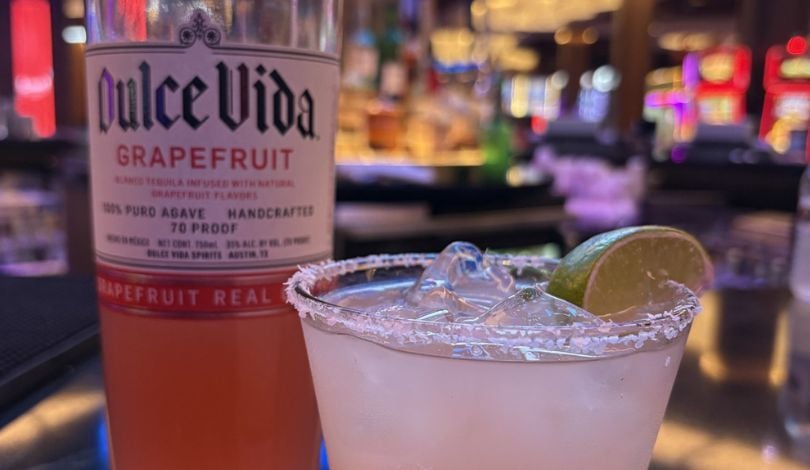 paloma margarita in a glass next to a bottle of dulce vida tequila