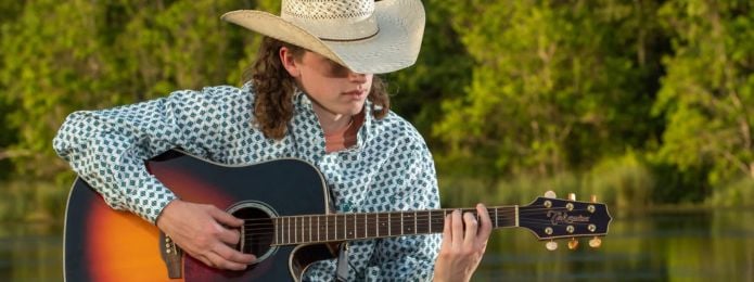 image of a man playing a guitar in a cowboy hat