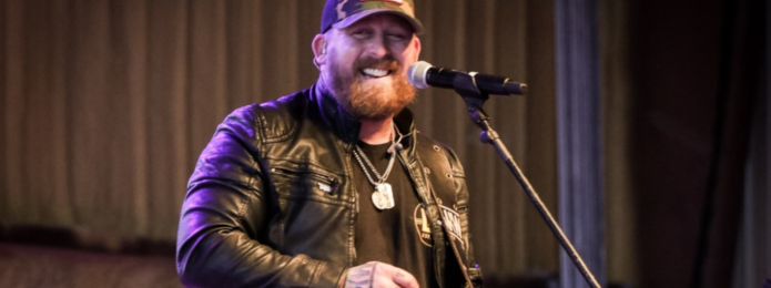 image of a man wearing black performing on a microphone