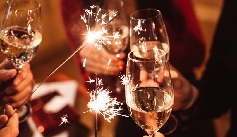 image of people celebrating with sparklers and champagne glasses