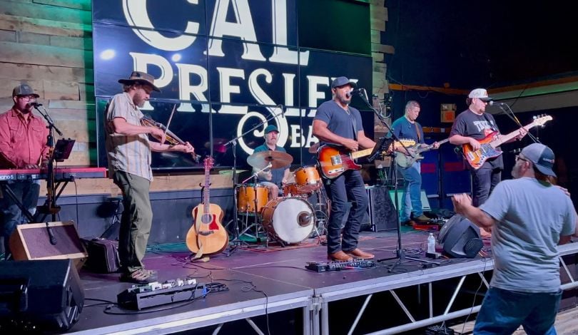 image of cal presley band playing instruments on stage